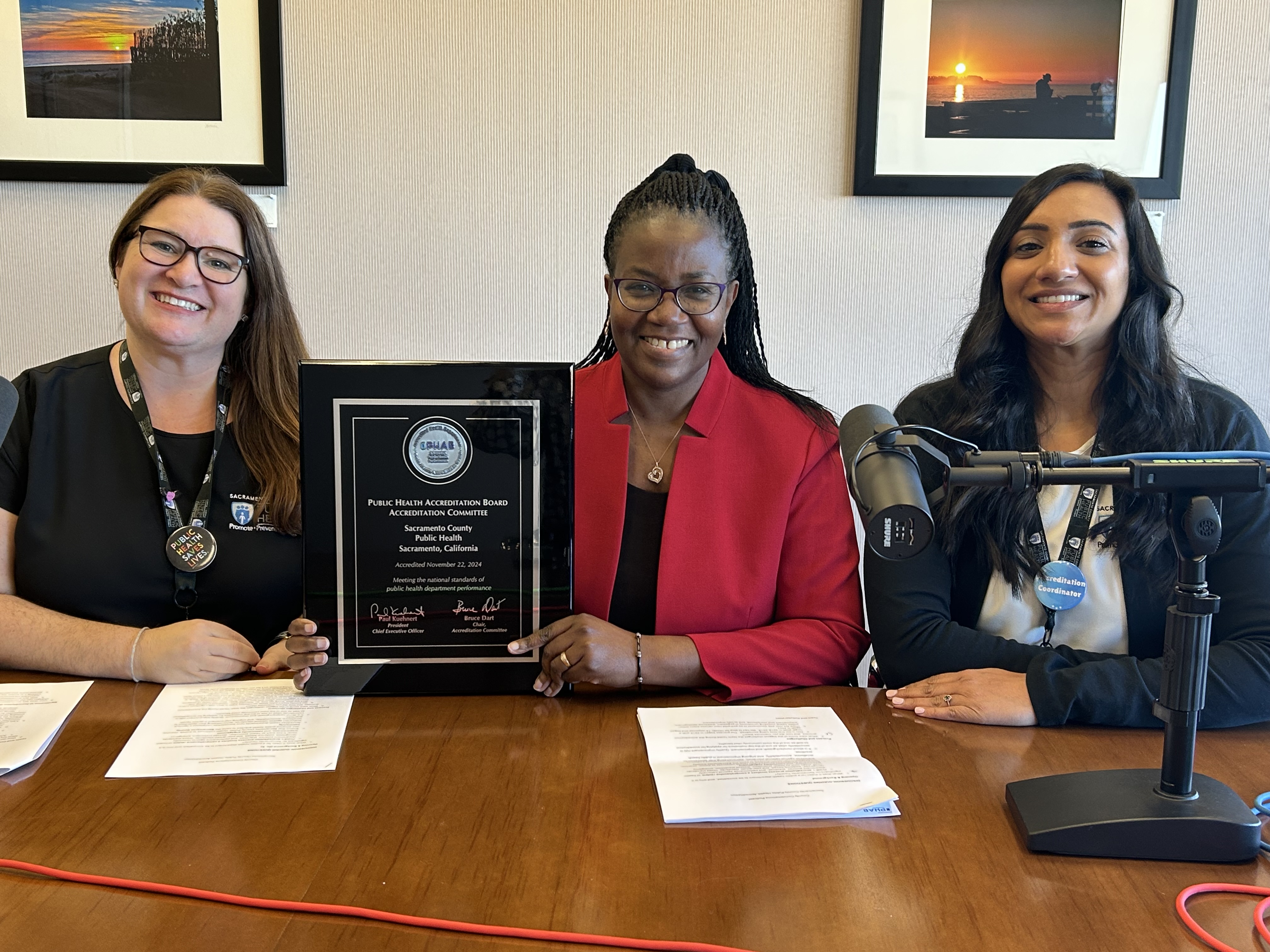 Doctor Olivia Kasirye, Megan Sheffield, and Dr. Gurleen Roberts sitting at a podcast table