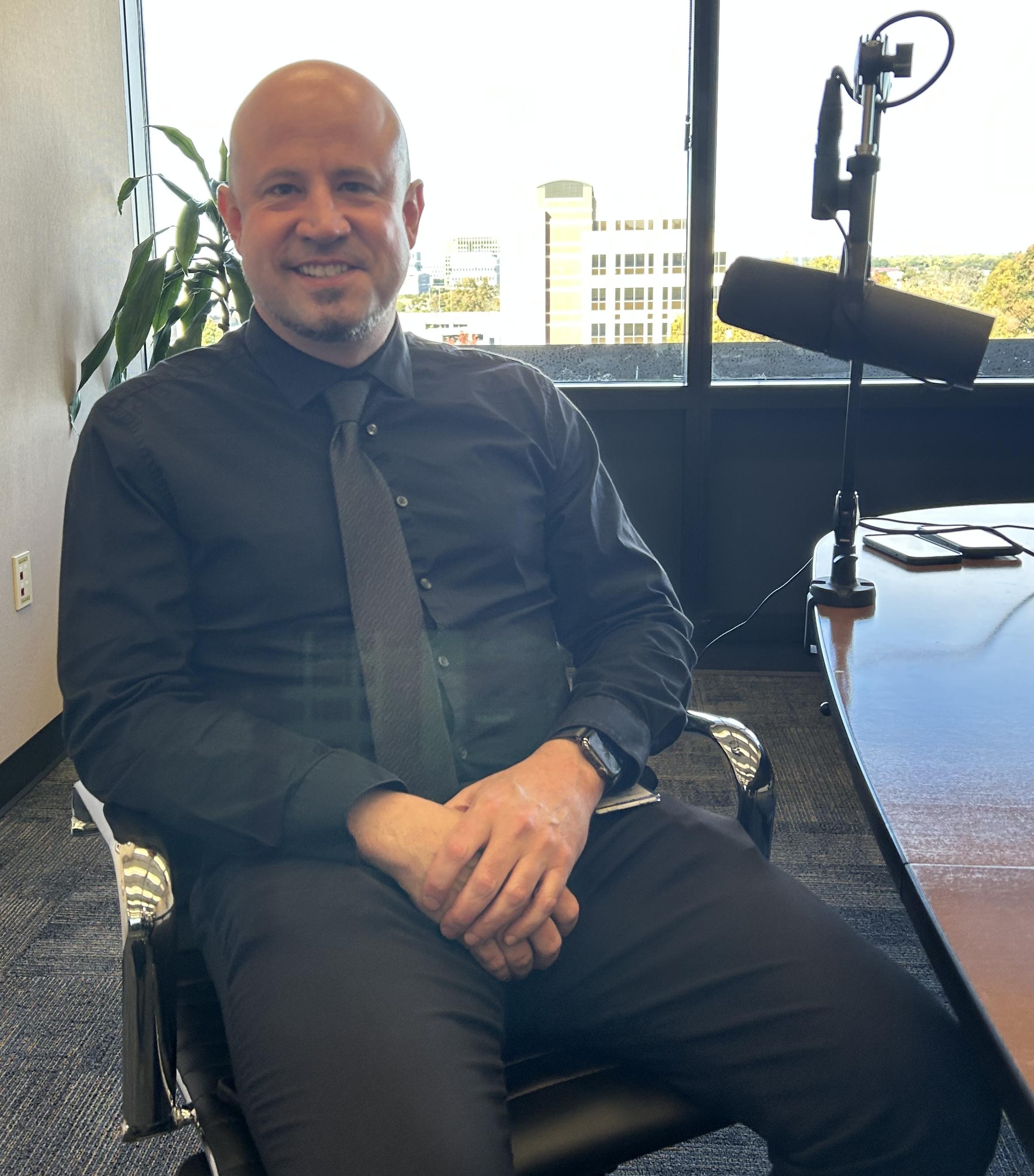 Doctor Ryan Quist sitting at a podcast table